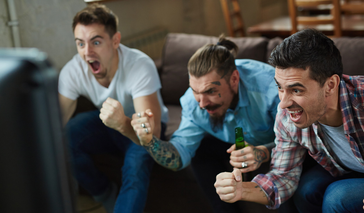 3 men cheering on sports on the tv