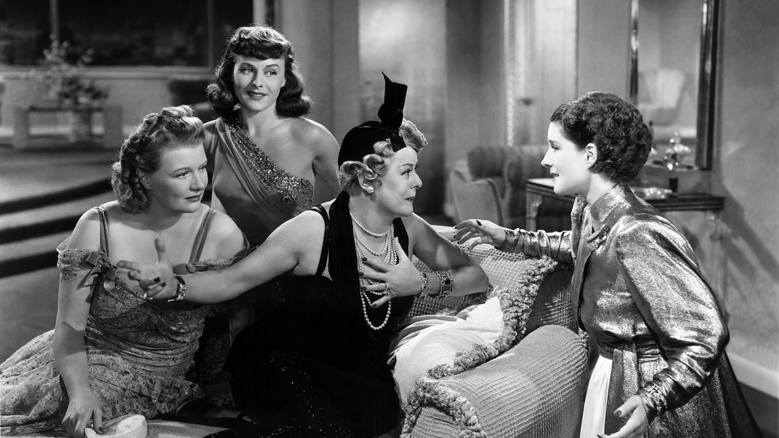 black and white photo of four women talking