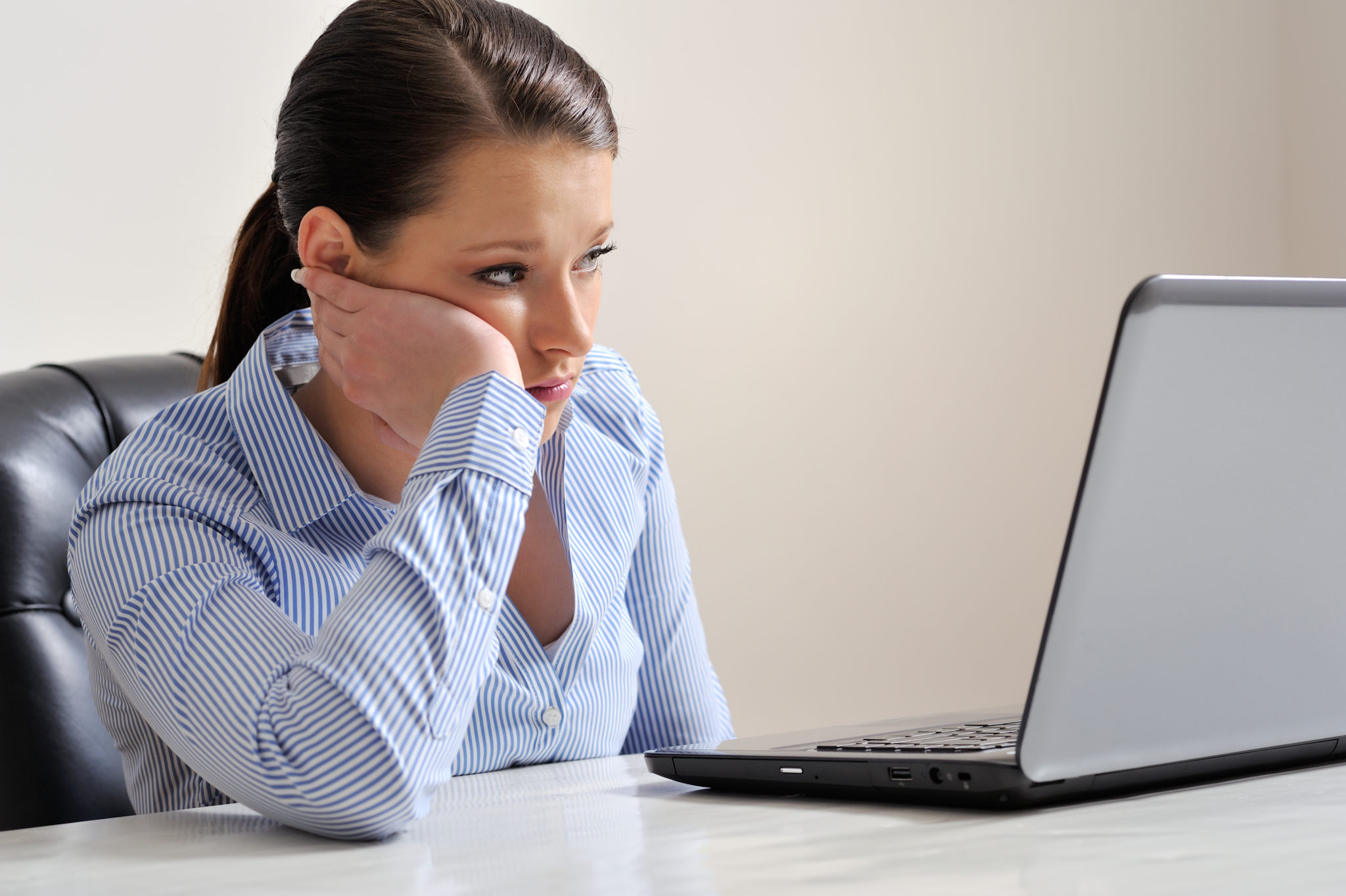 Woman on laptop looking disappointed