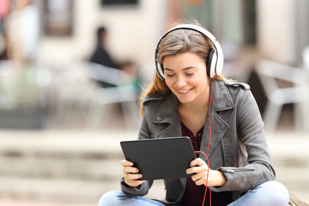 Girl on tablet listening to headphones
