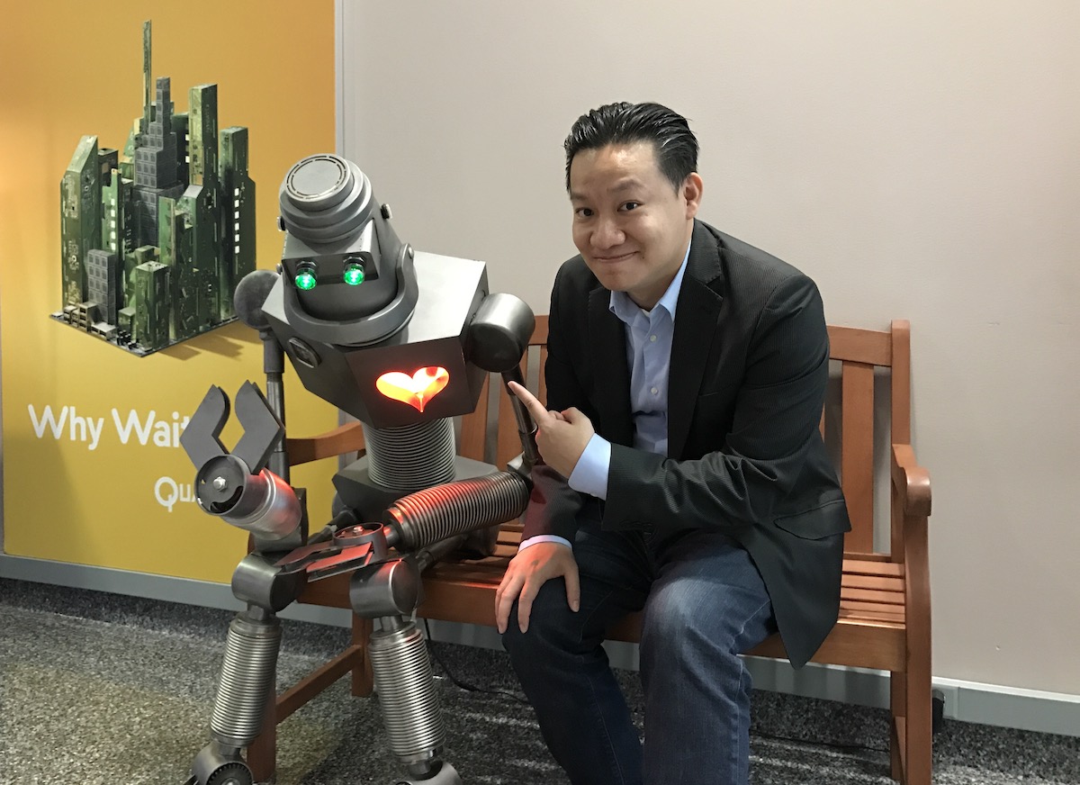 Editor in Chief Roger Cheng next to a robot.